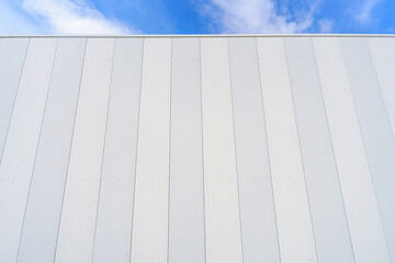 Fototapeta na wymiar White metal sheet rooftop wall on commercial building with blue sky