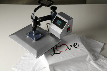 Printing logo. Heat press with t-shirt on white table
