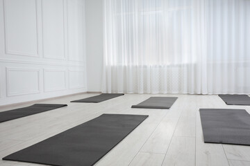 Spacious yoga studio with exercise mats. Space for text