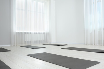 Spacious yoga studio with exercise mats. Space for text