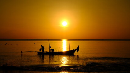 Fototapeta premium picture of sunrise at the beach and fishermen working in the morning Marine photographs on fishing documentaries.
