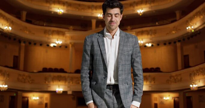happy talented male performer speaks from stage and thanks audience, raising arms up, expressing gratitude, bow down, blowing kiss to people Slow motion Happiness after successful performance Success