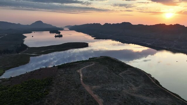 Sunset aerial view of Steenbras Dam, Cape Town, one of the City's major water supplies, on a windless evening. Steenbras Mountains and Sir Lowry's Pass  in background. Slow pan.