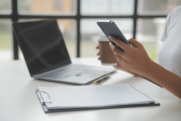 Asian Businesswoman Using laptop computer and working at office with calculator document on desk, doing planning analyzing the financial report, business plan investment, finance analysis concept.