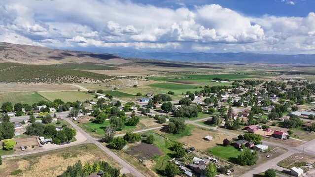 Aerial rural city farms agriculture mountains 1. Farming community agricultural economy. Spring summer weather mountain valley green agriculture field. Homes, barns and buildings.