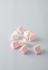 Marshmallow with white and pink hearts on a light background.