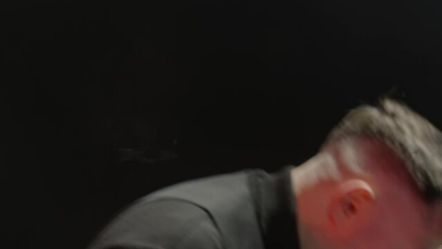 Dedicated artist playing keyboard with band. Musicians are performing together on stage. Handheld shot of performers having fun in rock concert. 