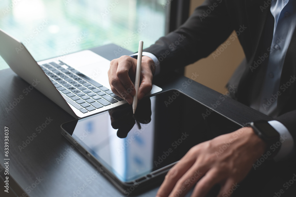Poster closeup of businessman using stylus pen signing e-document on digital tablet and working on laptop c