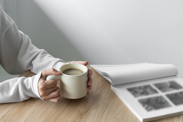 a woman sitting at a table with a cup