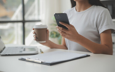 Asian Businesswoman Using laptop computer and working at office with calculator document on desk, doing planning analyzing the financial report, business plan investment, finance analysis concept.