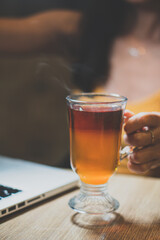 Close up warm black tea cup on wooden table in cafe , relax with tea time concept