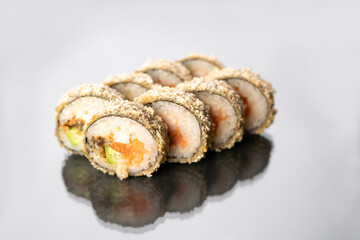 Hot fried sushi roll with salmon on white background with reflection. Sushi menu. Japanese food. Hot fried sushi roll