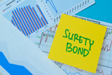 Concept of Surety Bond write on book isolated on Wooden Table.