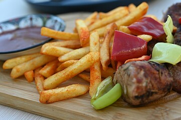 french fries with pieces of meat and tkemali sauce. Georgian cuisine