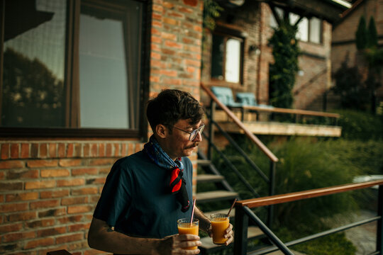 Male host bringing drinks to a pool party to his friends.