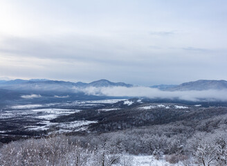 A winter morning in a mountainous area, a panorama of snow-capped mountains, slopes in a snowy...