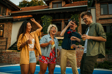 Group of well dressed crowd at a pool party dancing and having fun.