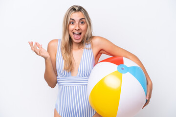 Young caucasian woman holding beach ball isolated on white background with shocked facial expression