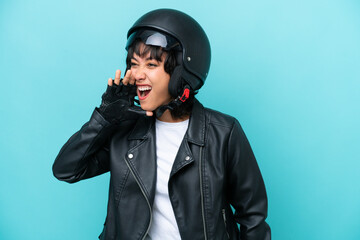 Young Argentinian woman with a motorcycle helmet isolated on blue background shouting with mouth wide open to the side