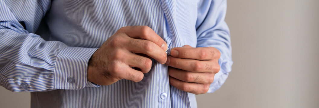 man hand buttons in shirt