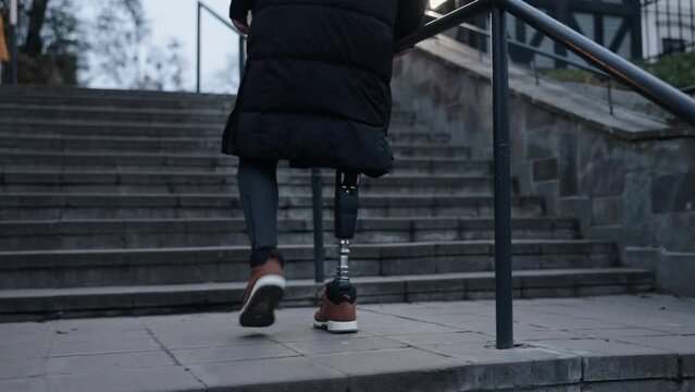 Independence climb, Disability pride, Prosthetic leg. Act of climbing stairs on city street accomplished by disabled man with prosthetic leg.
