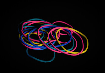 A closeup image of colorful rubber bands photographed with a black screen overlay.