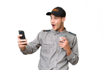 Young security man over isolated background holding coffee to take away and a mobile