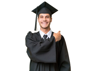 Young university graduate caucasian man over isolated background pointing back