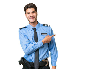 Young police man over isolated background pointing finger to the side