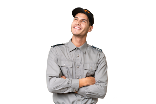 Young security man over isolated background looking up while smiling