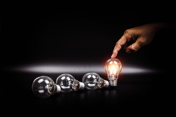 Close up hand choose light bulb or lamp with bright for human resources or leadership and...