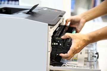 Technician hand open cover photocopier or photocopy to fix repair copier paper jam and replace ink...
