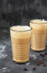 Two glasses of coffee with ice cream on a dark background.