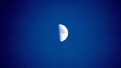シンプルな背景素材　真夜中の夜に輝く半月