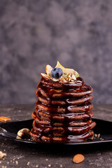 Vegan pancakes based avocado with cocoa and date syrup. Vegan healthy sweet food. Dark background