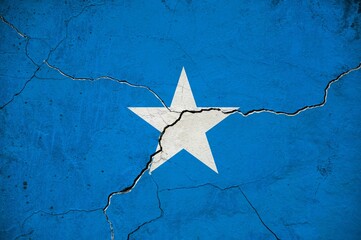 An image of the Somalia flag on a wall with a crack.