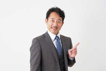 右側を指差すミドルエイジのビジネスマン　白背景