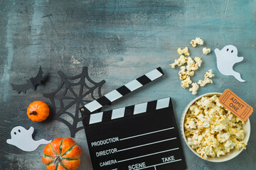 Horror movie night and Halloween party concept with  popcorn, pumpkin and movie clapper board on...