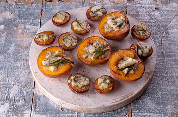 Grilled baked peach and plums stuffed with blue cheese dorblu and rosemary. Top view