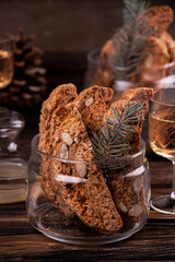Traditional italian Christmas New Year dry cookies biscuits biscotti cantuccini in glass bowl on wooden background. Biscotti di Prato.