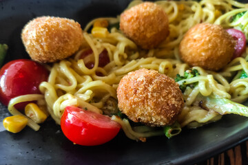 Meatballs in breading with noodles and vegetables