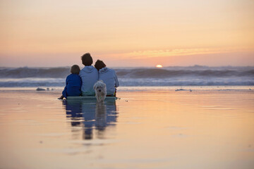 Fototapeta premium Happy children, boys, playing on the beach on sunset, kid cover in sand, smiling, laughing