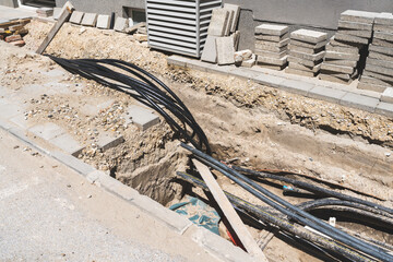 laying fiber optic cables underground on street in the city. Internet cable in ground