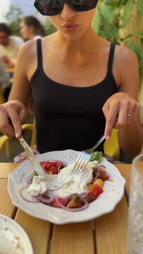 A girl is savoring burrata cheese in a restaurant.