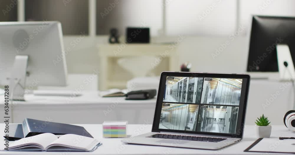 Sticker Laptop on office desk showing four security camera views of computer server room, slow motion