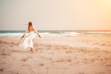 woman sea white dress. Model in boho style in a white long dress and silver jewelry on the beach....
