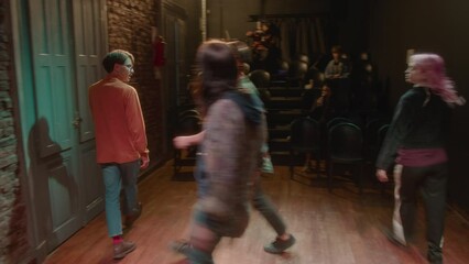 Group of young talented actors performing drama on stage of modern theater during rehearsal