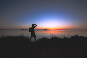 Silhouette of man watching the sunrise in the Mar Menor, Cartagena