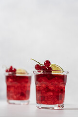 Red currant mojito in glasses with ice on white background with copy space. Refreshing berry drink