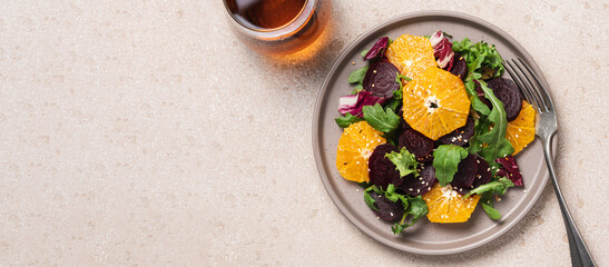 Seasonal vitamin salad orange beetroot and arugula in plate on light background. Diet, healthy eating concept